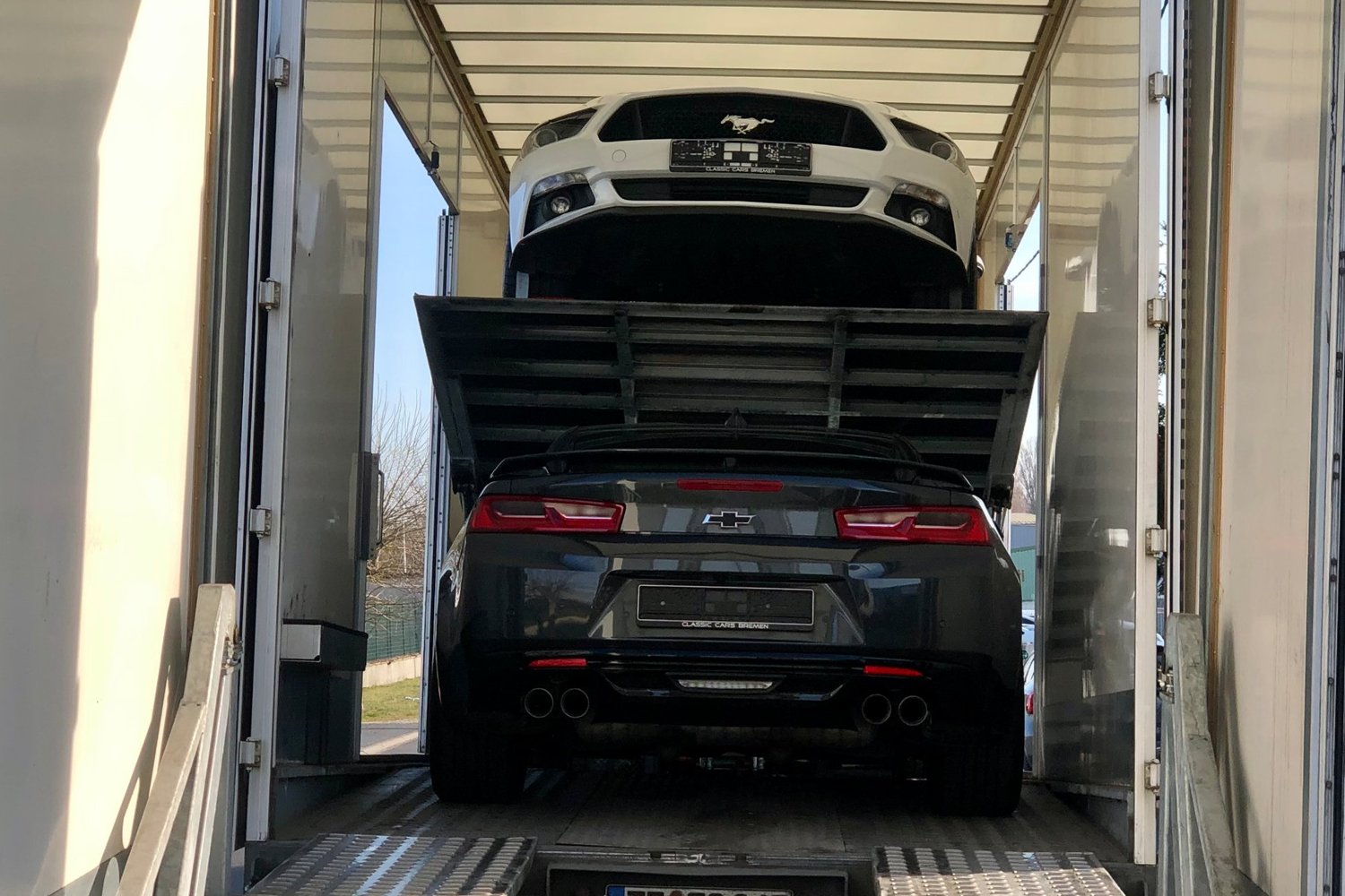 Chevrolet Camaro et Ford Mustang importées livrées en camion fermé